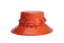 Load image into Gallery viewer, A glossy orange bucket hat with a wide brim and a braided orange band around the crown, shown on a plain white background.