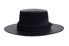 Load image into Gallery viewer, Hat swathed in rich black velour fabric and a brim made of black synthetic leather with a double braid velour trim, front view
