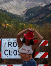 Load image into Gallery viewer, Girl wearing the dolly red hat in front of a sign 
