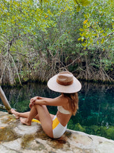 Load image into Gallery viewer, Girl posing in a lake with a vegan straw hat
