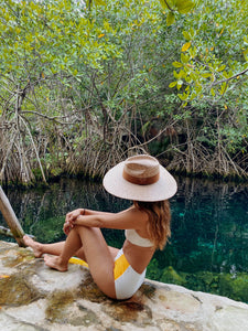 Girl posing in a lake with a vegan straw hat