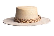 Load image into Gallery viewer, Straw hat in natural color made with palm leaves and the brim is made of structured suede finished with a combination braided trim, front view
