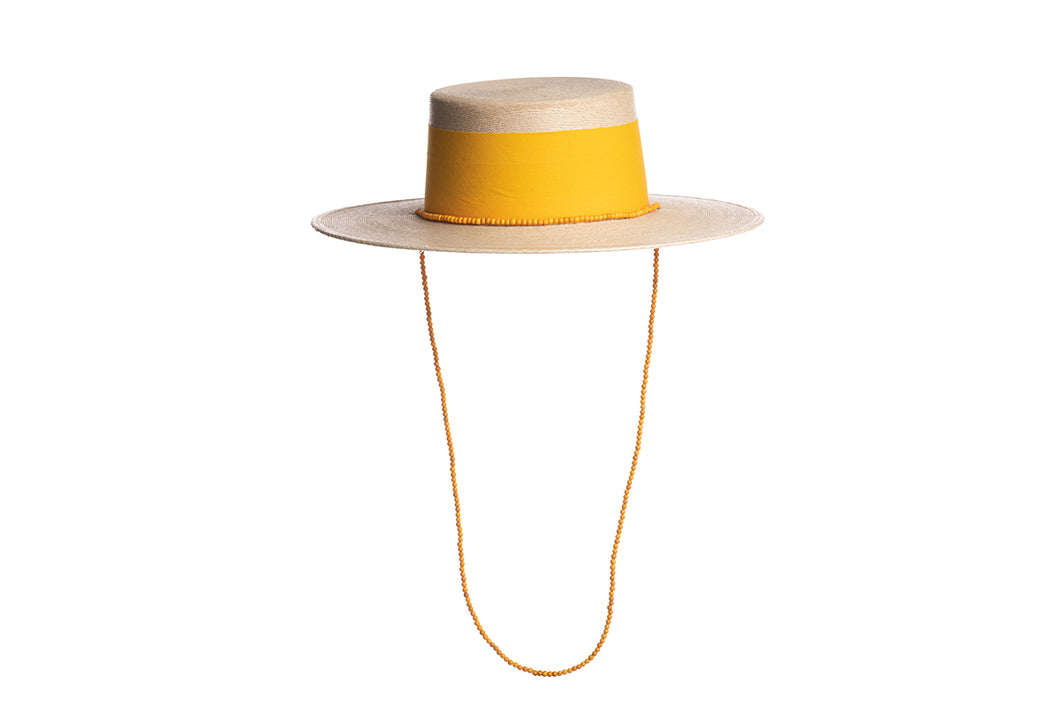 Wide tan brim palm hat with a yellow wide cotton trim and a yellow beaded chain, front view
