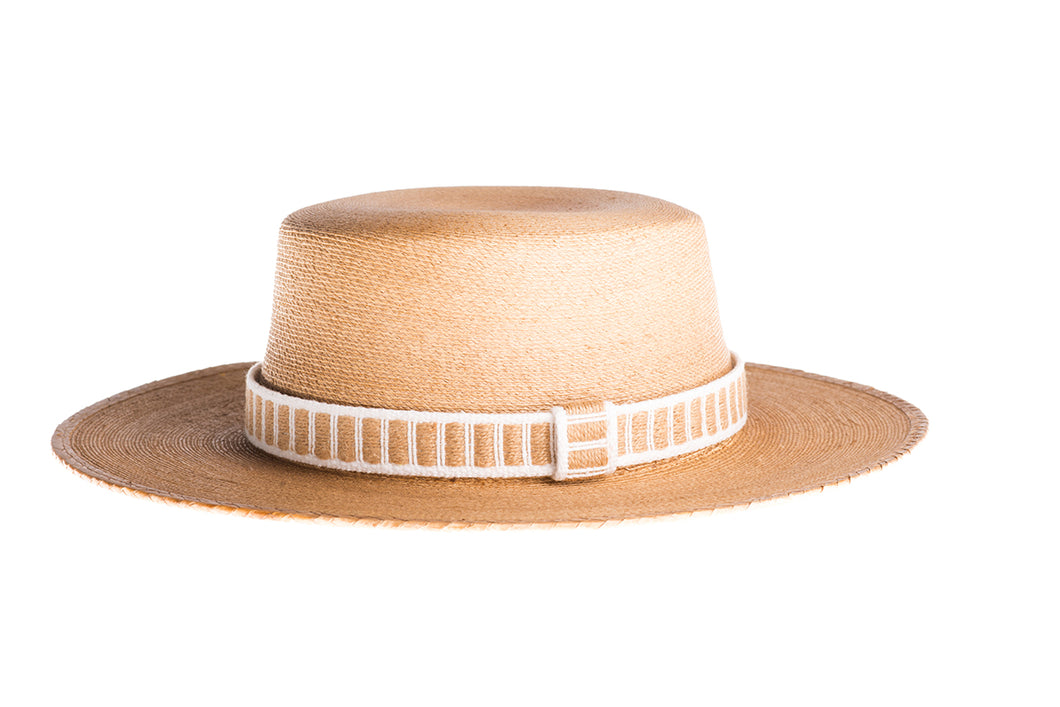 Straw hat made of palm leaves in tan color completed with a rustic cotton and jute trim, left side view