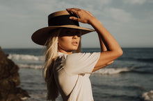 Load image into Gallery viewer, Girl posing in the beach with a hat made of palm leaves
