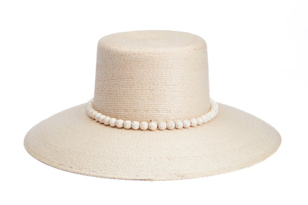 A light beige woven straw hat with a wide brim and a decorative band of white faux pearls around the crown, shown on a solid white background. Back side