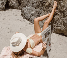 Load image into Gallery viewer, Girl posing in the beach with a straw hat made of palm leaves
