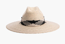 Load image into Gallery viewer, A light beige woven straw wide-brim hat with a black and white braided band around the crown and a black chin cord, shown against a plain white background. back side
