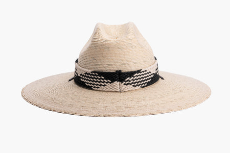 A light beige woven straw wide-brim hat with a black and white braided band around the crown and a black chin cord, shown against a plain white background. back side