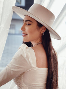 Girl posing with a white suede hat 