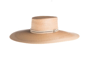 Hat with a flat top crown braid with palm leaves in natural color and an embroidered trim, left side view